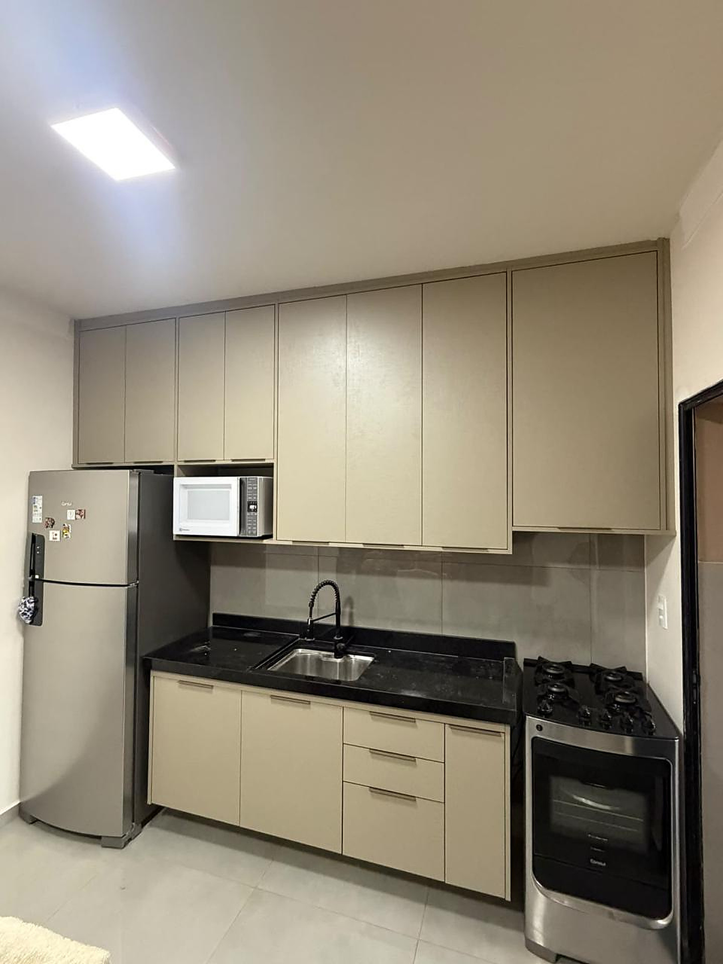 Cozinha completa com aéreos e iluminação linear